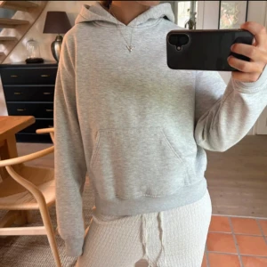 Ljusgrå basic hoodie från Gina - Enkel och stilren ljusgrå hoodie med huva och magficka. Tröjan har en relaxed passform och är tillverkad i mjuk bomullsblandning. Perfekt för chill dagar eller när du vill ha en clean look. Långärmad och ribbade muddar vid ärmslut och nederkant. Från Gina tricot i storlek S❤️❤️