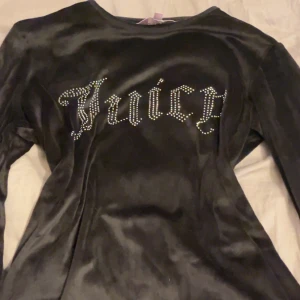 Svart sett Juicy Couture S - Svarta mjukisbyxor från Juicy Couture i glansig velour med elastisk midja. Baktill står det 'Juicy' i stora strasstenar för den ikoniska looken. Perfekta för dig som gillar comfy men ändå vill sticka ut. Köpt i USA för cirka 2500kr och är i bra skick , kan säljas separat för 500kr/st