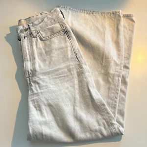Ljusgrå wide jeans från H&M, strl 34 - Säljer ett par ljusblå/grå jeans från H&M i storlek 34. De har hög midja och väldigt breda, raka ben. 