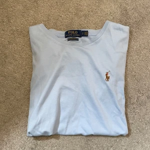Ljusblå t-shirt Polo Ralph Lauren - Hej, jag säljer nu denna feta Ralph Lauren T-Shirt eftersom att den inte passar längre. Modellen på bilden är 186cm lång, väger 70kg och bär storleken S. Jag skulle säga att tröjan skulle passa bättre på någon mellan 170-180cm lång. T-shirten är i 9,5/10 skick och är näst intill oanvänd. Tveka inte på att kontakta oss vid funderingar eller frågor⚜️🙌🔥