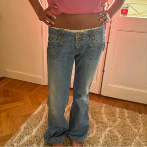 Lågmidjade ljusblå jeans - Säljer ett par riktigt snygga lågmidjade jeans från Pepe Jeans i ljusblå tvätt pga att dem tyvärr är för stora🥲 Jeansen har guldiga knappar och klassiska fickor både fram och bak. Midjemått: 39cm💕💕