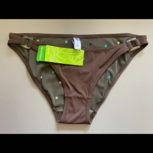 Bruna bikiniunderdel - Snygga bikiniunderdelar  i brun färg . Modellen har spännen i plast och en klassisk låg midja. Perfekt för strandhäng och poolparty!