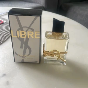 YSL Libre Eau de Parfum 50ml - YSL Libre Eau de Parfum i elegant, genomskinlig glasflaska med guldiga detaljer och svart asymmetrisk kork. Luktar jättegott  och håller hur länge som helst❤️ Innehåller 50 ml och endast tagit max 3 sprut. Köpt på kicks för ca 1500 kr i juni har online kvitto❤️