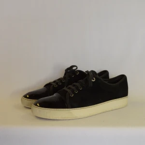 Lanvin captoe sneakers - LANVIN CAP TOE SNEAKER SVART  Storlek : 10  Passform : Passar 45  Användning : Skorna är i ett väldigt fint skick men finns små märken på captoe som ej syns tydligt samt att saken längst ut på snörena är borta  Nypris : Cirka 5000SEK