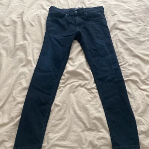 Replay grover jeans - Säljer ett par mörkblå skinny jeans med klassisk femficksdesign och dragkedjegylf. Snygg passform som sitter tight hela vägen ner och passar perfekt till sneakers eller boots. Materialet är stretchigt jeans för extra komfort. 31/30