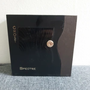 Ghost Spectre parfym 80ml - Ghost Spectre Eau de Parfum från French Avenue, 80ml. Flaskan är svart med metallisk finish och har en unik, vågig form med detaljer i guld, bland annat en patronformad dekoration. Kommer i en lyxig svart förpackning med guldtext. (10% använd)