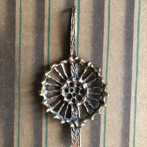Vintage bronshänge till halsband  - Unikt halsband i brons med ett stort, runt hänge, 9cm. Hänget har ett coolt, organiskt mönster med hål i mitten och detaljer som påminner om kronblad. Perfekt statement piece för dig som gillar retro och boho vibes. Alton KE Palmberg