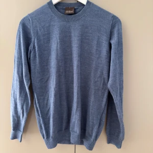 Blå merinoulltröja Oscar Jacobson S - Snygg blå rundhalsad tröja från Oscar Jacobson i 100% merinoull. I stort sett nyskick!