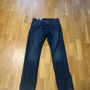 Levi's 501 mörkblå jeans W36 L34 - Klassiska Levi's 501 jeans i mörkblå tvätt med raka ben och femficksdesign. Jeansen har knappgylf och är tillverkade i slitstarkt bomullsjeans. Perfekta för dig som gillar en tidlös och avslappnad look.