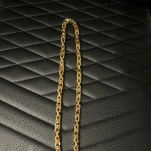 Tungt guldhalsband med kedjelänkar - Säljer ett maffigt halsband i guldton med kraftiga, rektangulära kedjelänkar. Halsbandet har en cool och robust design som sticker ut och passar perfekt för dig som gillar statement-smycken.