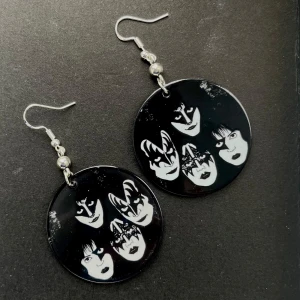 Svarta örhängen med KISS-motiv - Coola runda örhängen i svart med vit tryck av KISS-motiv. Nickelfria krokar.❤️