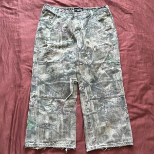 Camo wide jeans - Ganska slitna men jävligt feta camo jeans. Knäna är dubbelfodrade så det stora hålet går inte igenom till benen. Fråga för fler bilder
