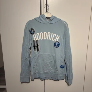 Hoodrich hoodie - En ljusblå hoodrich hoddie som är lite använd och har ett märke på ena armen men inget man tänker på. Storlek M