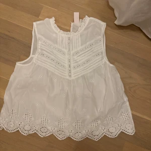 Vit ärmlös blus med broderade detaljer - super söt blus. aldrig använd 