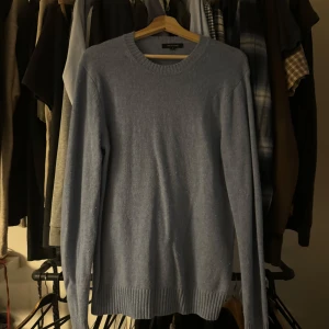 Lljusblå stickad tröja från Paul & friends - Säljer en ljusblå stickad tröja från Paul & friends. Tröjan har rund halsringning, långa ärmar och ribbade muddar vid ärmslut och nederkant. Perfekt för lager-på-lager under kyliga dagar.