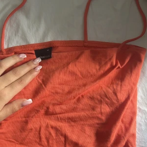 Orange linne  - Säljer en orange basic linnetopp från Gina Tricot med tunna axelband. Dubbla lager tyg upptill. Storlek M men  S funkar lika bra 