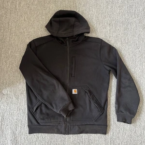 Carhartt hoodie - Säljer denna svarta hoodie från Carhartt i storlek M. Lite tjockare hoodie som även kan användas utomhus till våren. Sparsamt använd och i mycket fint skick. Fraktar samma dag. Priset kan diskuteras vid snabb affär.
