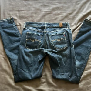 Blå Replay jeansbyxor - Säljer ett par klassiska blå jeans från Replay med snygg färg och kontrastsömmar. Byxorna har fem fickor, dragkedja och knapp i midjan samt Replay-logga på fickan. W30 L32