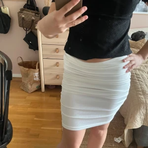 Vit ribbad kortkjol  - Säljer en vit ribbad kortkjol med tight passform. Kjolen har en enkel och stilren design som passar perfekt till många olika outfits. Materialet är stretchigt och bekvämt. Köpt på shein 