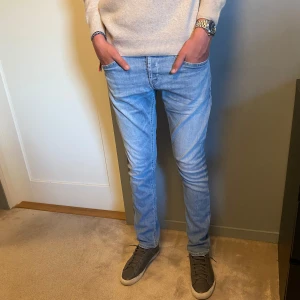 Dondup jeans - Säljer dessa riktigt snygga ljus blå Dondup jeans  som passar perfekt nu till sommaren.  Modellen är skinny fit.  Människan på bilden är 174 cm lång.