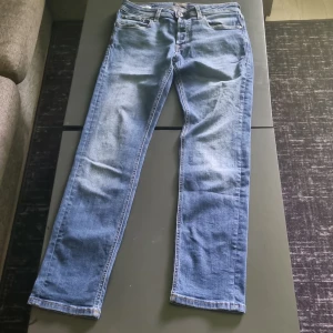 Blå slim straight jeans - Säljer ett par klassiska blå jeans med slim straight passform. Jeansen har fem fickor, dragkedja och knapp i midjan samt snygga kontrastsömmar. Perfekta för dig som gillar en smal men rak siluett. Storlek W31 L32. PRIS:250KR