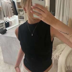 Svart ärmlös topp från Zara - Snygg svart ärmlös topp från Zara. Perfekt för en stilren look. Toppen har en enkel design som gör den lätt att matcha med olika accessoarer🤎🤎