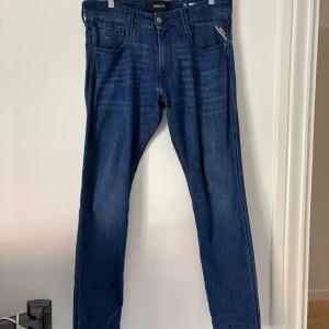 Mörkblå replay jeans - Säljer ett par mörkblå replay jeans med slim fit och normal passform. Byxorna har fem fickor, bälteshällor och stängs med dragkedja och knapp. Säljer dessa för tycker inte om längre!