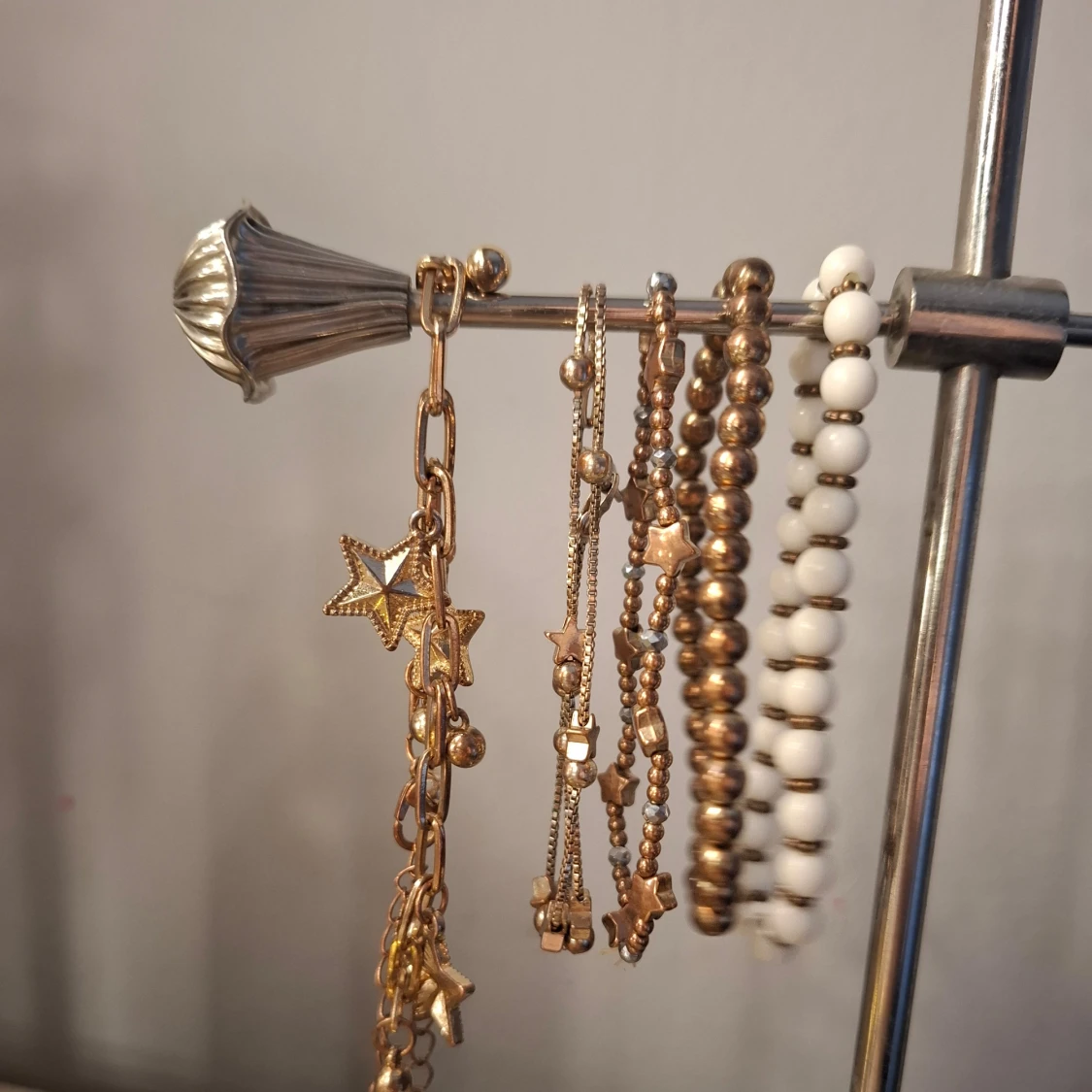 Set med armband i guld och vitt med stjärndetaljer