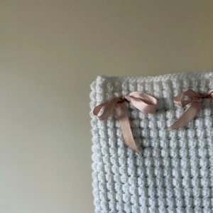 Virkad datorfodral  - Superfin handgjord datorfodral i vitt virkat material med bubblig struktur. Säkras med rosetterna som för övrigt går att välja färg på! 