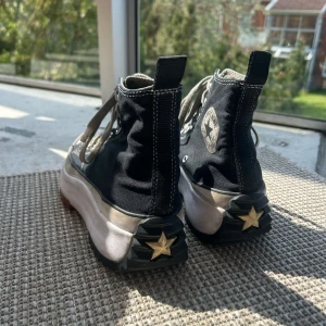 Svarta Converse Run Star Hike - Säljer ett par svarta Converse Run Star Hike med högt skaft och grov, räfflad sula i vitt, svart och brunt. Skorna har klassisk Converse-logga på sidan, snörning och stjärndetalj på hälen. Perfekta för dig som vill sticka ut med din stil.