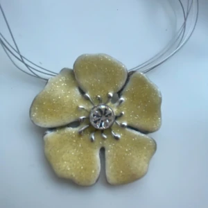 Halsband - Ett halsband med en stor blomma. Halsbandet är ganska kort. Kommer inte till användning då det inte är min stil.