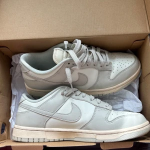 Nike Dunk Low bone white sneakers - Säljer dessa sneakers åt min kille i storlek 42 1/2. De är i bra skick och har inga defekter då de endast är använda vid ett tillfälle. Nypris: 1899kr 