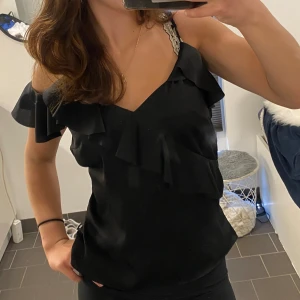 Svart volangtop  - Snygg svart topp med volangdetaljer och offshoulder-design. Har sytt in midjan lite själv så det finns ett litet snöre som knappt syns! Köpte den från HM för lite mer än 200 och säljer för 90!❤️