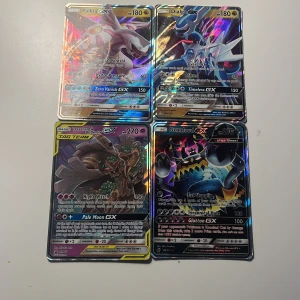 Pokémon GX-kort, 4-pack - Fyra Pokémon GX-kort: Palkia GX, Dialga GX, Trevenant & Dusknoir GX Tag Team, samt Guzzlord GX. Alla korten är holografiska och har färgstarka motiv med detaljerad design. Perfekt för samlare eller Pokémon-entusiaster som vill utöka sin samling.
