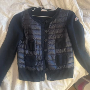Svart Moncler cardigan  - Säljer nu min svarta Moncler cardigan/ kofta i S då den håller på och bli förliten. Inget kvitto utan bara skannings grejen som ni ser på bild 2. Kan tänka mig byta mot den andra modellen i M 