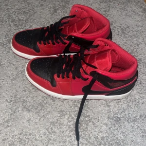 Nike jordan 1 HELT NYA ! - Säljer ett par klassiska Nike Air Jordans i rött och svart med vita sulor. Skorna har svart snörning, rund tå och platt sula. Perfekta för dig som gillar streetwear och vill sticka ut med en ikonisk sneaker.