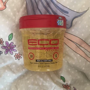 Eco Styler Argan Oil Styling Gel - Eco Styler Professional Styling Gel med arganolja, vattenbaserad och passar alla hårtyper. Kommer i en stor burk på 473 ml med röd lock och genomskinlig gul gel. Perfekt för att definiera, återfukta och ge glans till håret. Använd 2-3 gånger 