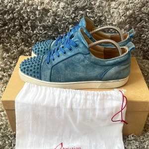 Loubs - Unika blå sneakers från Christian Louboutin i mocka. Skicket är relativt bra, jag har även lagat de inuti så att de håller bättre. Alla nitar är kvar. Du får med box, dustbag samt papper och annat. Skriv ifall du vill ha fler bilder. Skriv till mig ifall du vill veta defekterna på de. Det är knappast några alls. 