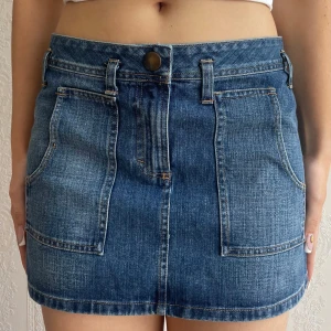 Low waist jeanskjol - Säljer en low waist mörkblå jeanskjol med snygga framfickor från märket ”United colors of Benetton”! Har aldrig kommit till användning och är därför i jättebra skick💞