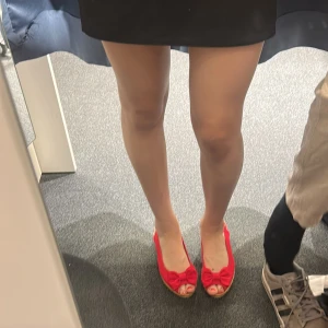 Röda kilklackar med rosett, stl 39 - Snygga röda kilklackar med öppen tå och söt rosett framtill. Skorna har en flätad sula i espadrillestil och är tillverkade i tyg. Perfekta för sommarens alla tillfällen när du vill sticka ut lite extra och även bekväma!