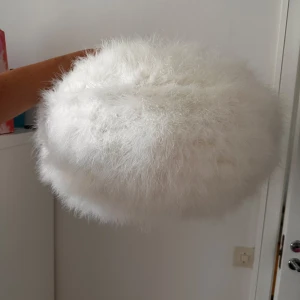 Vit fluffig lampa - Supermjuk och fluffig vit lampa med rund form. Lampan har en riktigt lyxig känsla och är perfekt för att sticka ut. Den är helvit och täckt av lång, mjuk päls. Den kan vikas och har inga defekter.