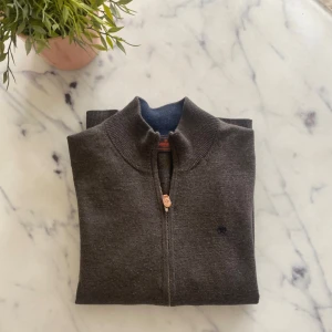 Brun ziptröja i merinoull från Morris - Säljer en brun stickad ziptröja från Morris i 100% merinoull. Tröjan har hel dragkedja framtill, ribbade muddar och en liten broderad logga på bröstet. Jag är ~175 och den passar bra på mig. Skicket är 9,5/10 så nästan helt ny‼️kan gå ner i pris vid snabb affär 🤝nypris nästan 2000kr