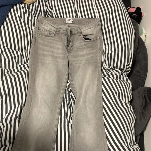 Grå bootcut jeans från 157 - Snygga grå jeans från 157 med bootcut-modell och klassisk femficksdesign. Jeansen har normal passform och är tillverkade i mjukt denimtyg. Perfekta för dig som gillar en avslappnad men trendig look.