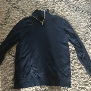 Mörkblå half zip tröja Jack & Jones - Mörkblå långärmad tröja från Jack & Jones med half zip-dragkedja i halsen. Perfekt för en mysig sommarkväll 