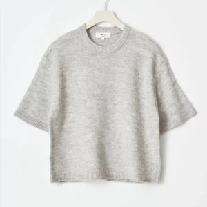 Grå stickad kortärmad tröja  - Supermjuk och stilren grå stickad tröja från Gina Tricot med korta ärmar och avslappnad passform. Perfekt till jeans eller shorts för en chill look. Rund halsringning och ribbade kanter ger en clean vibe.