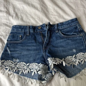 Blå sommriga jeans shorts från zara med söta blomm detaljer 💐 - Midjemåttet är runt 28 cm. Skicket på jeans shortsen är väldigt bra 