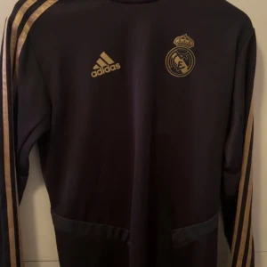 Real Madrid tröja  - Säljer denna exklusiva tröja som representerar Real Madrid, köpt på fotbollsmässiga för länge sedan men nästan aldrig använts, Storlek S men har relativt luftig passform så kan passa större! PM FÖR MER INFO📍