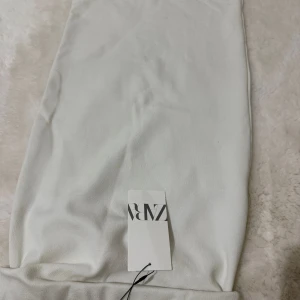 Vit långkjol från Zara - Stilren vit långkjol från Zara i mjukt material. Kjolen har en enkel och clean design som gör den lätt att matcha med olika toppar och accessoarer. Perfekt för dig som gillar minimalistisk stil.