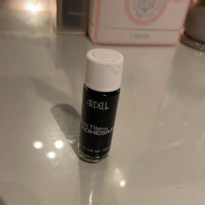 Ardell franslim LashTite svart - Ardell LashTite Adhesive är ett svart franslim i liten flaska med vit skruvkork. Perfekt för att fästa lösögonfransar och ger ett hållbart resultat. Smidig att ta med i sminkväskan och enkel att applicera.