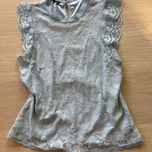 Ljusblå spetsblus  - Superfin ljusblå blus i spets med blommigt mönster. Blusen har korta ärmar med vågig kant och rund halsringning med söt spetsdetalj. Jag vet inte om man ser men på bröstkorgen/upp mot halsen är den missfärgad lite grönt. Men det syns inte så mycket. Skriv vid frågor💕💕💕
